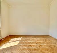 Ein leerer Raum mit Holzboden und einem großen Fenster in einer 3-Zimmer-Wohnung.