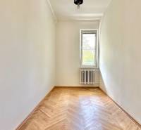 Ein Zimmer mit hellen Wänden, Holzboden, Heizkörper und Fenster in einer 3-Zimmer-Wohnung.