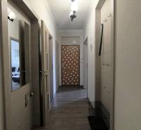 Der Flur in der 2-Zimmer-Wohnung mit Holztüren und dekorativen Sternen.