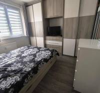 Schlafzimmer in einer 2-Zimmer-Wohnung mit Einbauschrank, Bett und Kommode.