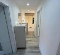 Der Flur in einer 2-Zimmer-Wohnung mit Holzboden und weißen Wänden.