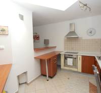 Eine Küche in einem Einfamilienhaus mit Geräten, einer Holzzeile und einer gefliesten Wand.