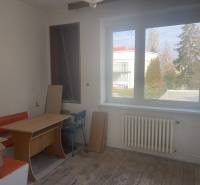 Innenraum eines Einfamilienhauses mit Fenster, Tisch und orangefarbener Bank.