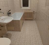 Badezimmer in einem Einfamilienhaus mit Badewanne, Waschbecken, WC und Heizkörper an der Wand.
