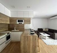 Wohnzimmer und Küche in einer 3-Zimmer-Wohnung mit Holzboden und Möbeln.