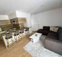 Wohnzimmer in einer 3-Zimmer-Wohnung mit Küche, Bartresen und Ecksofa.