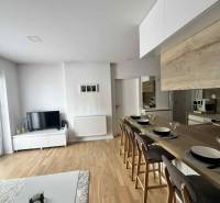 Heller Wohnbereich mit Fernseher, Küche und Esstheke in einer 3-Zimmer-Wohnung.