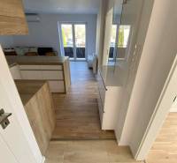 Helle Innenausstattung einer 3-Zimmer-Wohnung mit Holzboden und Zugang zur Terrasse.