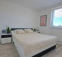 Helles Schlafzimmer mit Einrichtung und Bett in einer 2-Zimmer-Wohnung, minimalistisches Design.