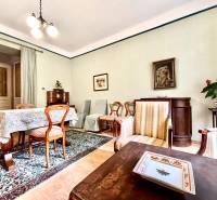 Wohnzimmer in einer 2-Zimmer-Wohnung mit Holzmöbeln und einem bunten Teppich.