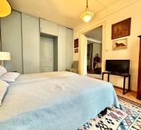 Schlafzimmer in einer 2-Zimmer-Wohnung mit Ehebett und antiken Möbeln.