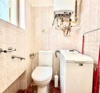Badezimmer in einer 2-Zimmer-Wohnung mit WC, Waschmaschine und Gastherme an der Wand.