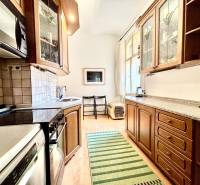 Küche in einer 2-Zimmer-Wohnung mit Holzschränken, Herd und geräumiger Arbeitsplatte.