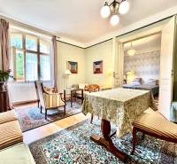 Traditionelles Interieur einer 2-Zimmer-Wohnung mit Teppich, Möbeln und Zimmerpflanzen.