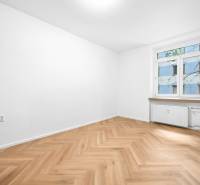 Ein Zimmer in einer 3-Zimmer-Wohnung mit Holzboden und einem großen Fenster.