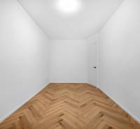 Ein leerer Raum mit weißen Wänden und Holzboden in einer 3-Zimmer-Wohnung.