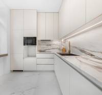 Weiße Küche mit Marmorplatte und Spüle in einer 3-Zimmer-Wohnung.