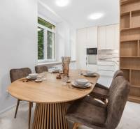 Helle Küche mit ovalem Tisch, vier Stühlen und großem Fenster in einer 3-Zimmer-Wohnung.