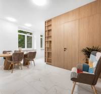 Esszimmer in einer 3-Zimmer-Wohnung mit Holztisch, Stühlen und dekorativem Sessel.