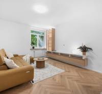 Wohnzimmer in einer 3-Zimmer-Wohnung mit Sofa, Couchtisch und Holzboden.