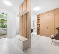 Helle Innenausstattung einer 3-Zimmer-Wohnung mit Holzelementen und einem Relaxsessel.
