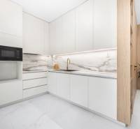 Küche in einer 3-Zimmer-Wohnung mit weißen Schränken und einer Marmor-Arbeitsplatte.