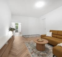 Wohnzimmer in einer 3-Zimmer-Wohnung mit braunem Sofa und Holzmöbeln.