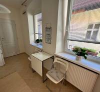 Küche mit Fenstern, Tisch mit Stühlen, Blumen auf der Fensterbank, 2-Zimmer-Wohnung.