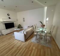 Wohnzimmer mit Sofa, Fernseher und Glastisch in einer 2-Zimmer-Wohnung.