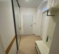 Flur in einer 2-Zimmer-Wohnung mit Einbauschrank und Bank, neutrales Design.