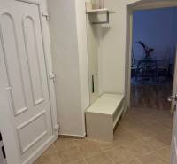 Eingangsflur einer 2-Zimmer-Wohnung mit weißen Möbeln und Fliesen.