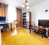 Wohnzimmer in einer 3-Zimmer-Wohnung mit Holzboden, Sofa und Schreibtisch.