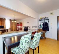 Innenraum einer 3-Zimmer-Wohnung mit Esstisch, Holztüren und Wandregalen.