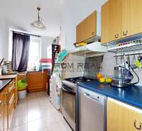 Küche in einer 3-Zimmer-Wohnung mit Holzschränken und Geräten.