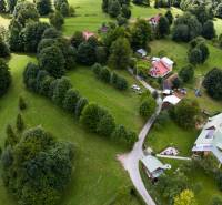 Luftaufnahme von Erholungsgrundstücken in Oščadnica, umgeben von dichtem Grün und Häusern.