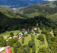 Luftaufnahme von bewaldeten Erholungsgrundstücken in Oščadnica mit ländlicher Bebauung.