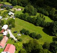 Luftaufnahme von Erholungsgrundstücken in Oščadnica, umgeben von Grünflächen und Gebäuden.