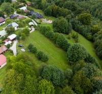 Luftaufnahme von Erholungsgrundstücken in Oščadnica, umgeben von Wäldern und Häusern.