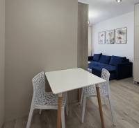 Essbereich mit Tisch und Stühlen in einer 2-Zimmer-Wohnung, weißes Interieur.