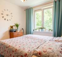Schlafzimmer in einer 3-Zimmer-Wohnung mit Bett, Nachttisch und Dekorationspflanzen.