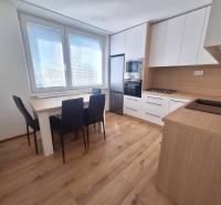 Küche in einer 2-Zimmer-Wohnung mit Esstisch, Herd und Geräten.