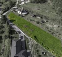 Luftaufnahme von Baugrundstücken in Raková, umgeben von Grünflächen und Häusern.