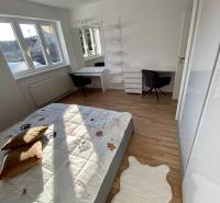 Schlafzimmer in einer 3-Zimmer-Wohnung mit Bett, Schreibtisch und Regalen, helle Holzböden.