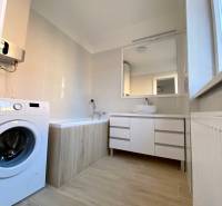 Badezimmer in einer 3-Zimmer-Wohnung mit Badewanne, Waschmaschine und Spiegelschrank.