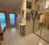 Der Flur in einer 2-Zimmer-Wohnung mit weißen Möbeln und einem Spiegelschrank.