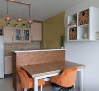 Essbereich in einer 2-Zimmer-Wohnung mit orangefarbenen Stühlen und Hängelampen.