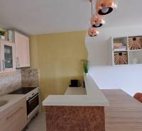 Küche in einer 2-Zimmer-Wohnung mit sanften Pastellfarben und Hängelampen.