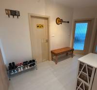 Der Flur einer 2-Zimmer-Wohnung mit Schuhschrank, Bank und Wanddekoration.