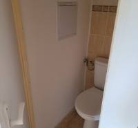 Toilette mit Fliesen und Eingangstüren in einer 3-Zimmer-Wohnung.