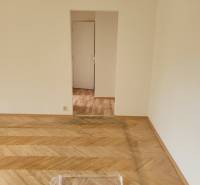 Ein Zimmer mit Holzboden und weißer Wand in einer 3-Zimmer-Wohnung.